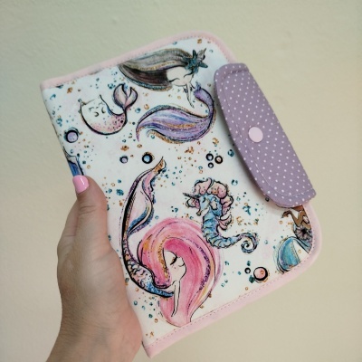 Carteira ou estojo com padrão de sereias coloridas e detalhe lilás com bolinhas