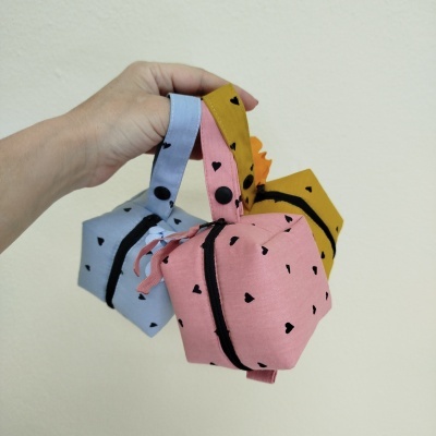 Três bolsas de tecido com padrão de corações e fecho preto