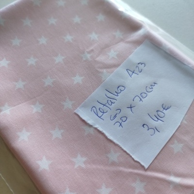 Tecido rosa com estrelas brancas embalado com etiqueta manuscrita