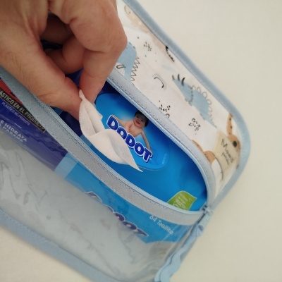 Embalagem azul de toalhitas Dodot dentro de estojo tecido com padrão de dinossauros.