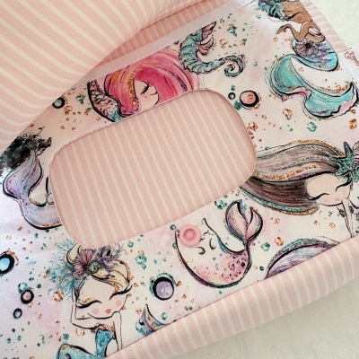 Produto têxtil com padrão de sereias em tons coloridos e interior rosa com riscas