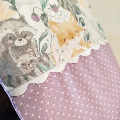 tecido lilás com bolinhas e tecido estampado com guaxinins e raposas em tons pastéis