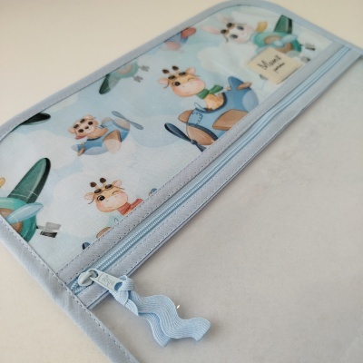 Carteira azul claro com desenhos de animais em aviões, zíper e etiqueta Mama premium.