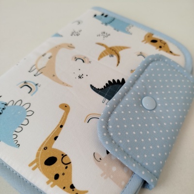 Carteira ou estojo com padrão colorido de dinossauros e fecho azul com bolinhas brancas