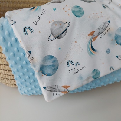 Cobertor de bebé com padrão espacial em tons de azul e tecido texturizado azul claro