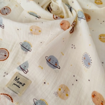 Tecido branco com padrão de planetas sorridentes e etiqueta Mamã pintinha