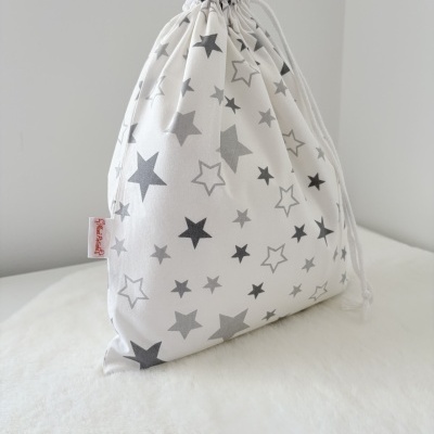 Saco de tecido branco com estrelas cinzentas e cordão branco