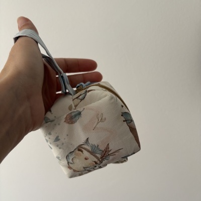 Mochila pequena de tecido branco com corujas e folhas e alça azul às riscas