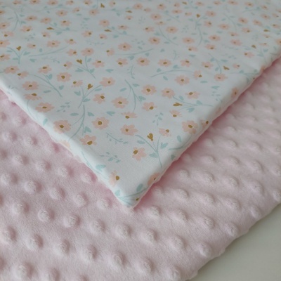 tecidos dobrados com padrão floral e textura bolinhas em cor rosa