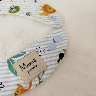 Babete de bebé azul e branco com padrões de animais e etiqueta 'Mamã pintinha'