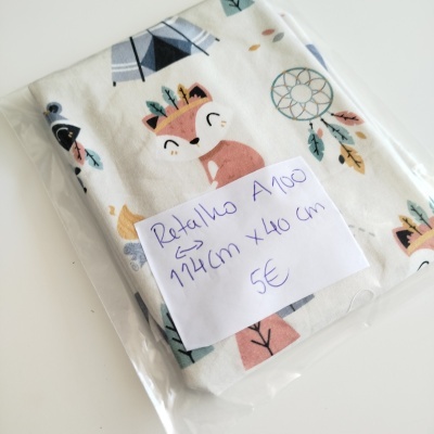 Retalho de tecido infantil branco com padrão de raposa e penas, embalado em plástico com etiqueta manuscrita.