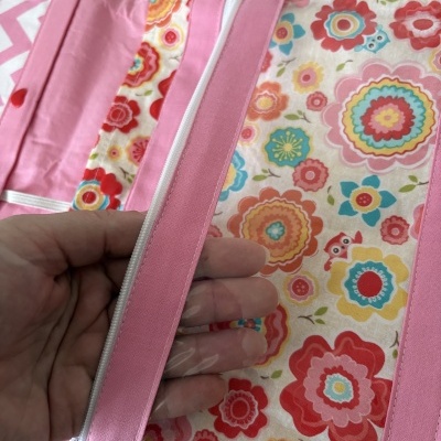 Bolsa de tecido rosa e floral com fecho de correr e plástico transparente