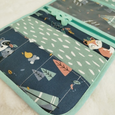 Carteira ou organizador com padrões de animais, folhas e zíper verde água