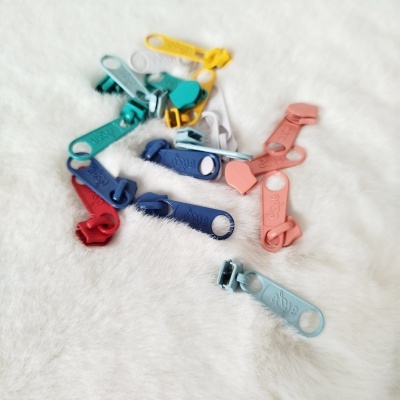 Puxadores de fechos éclair coloridos sobre tecido branco felpudo