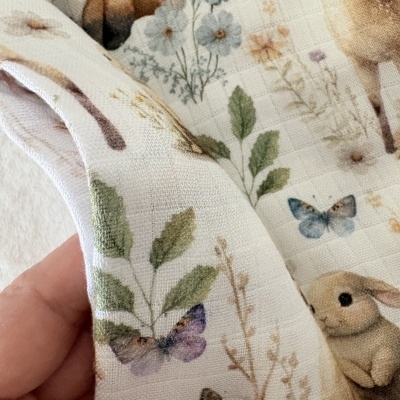 tecido branco com padrão de animais e flores coloridas