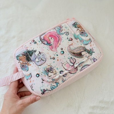 Bolsa de tecido rosa com padrão de sereias e riscas brancas