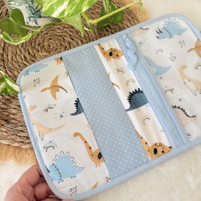 Estojo azul claro com padrão de dinossauros e bolsos internos
