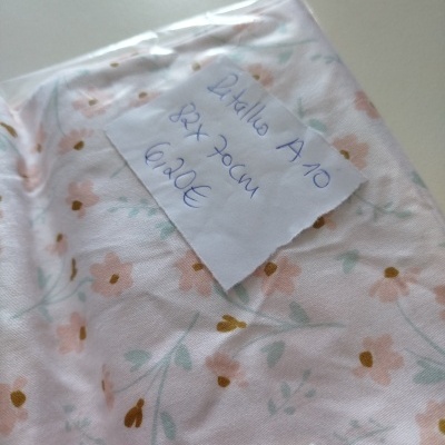 tecido floral rosa e verde embalado com etiqueta manuscrita