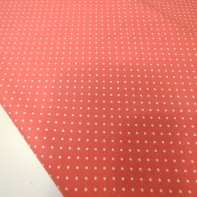 Tecido cor-de-rosa com pequenas bolinhas brancas