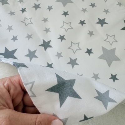Tecido branco com estrelas cinzentas em vários tamanhos e tons