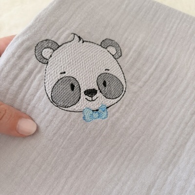 Pano branco com bordado de rosto de urso panda e laço azul claro