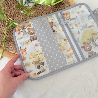 Carteira ou porta-documentos em tecido com padrão de animais da floresta e estrelas brancas.