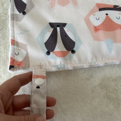 Tecido estampado com animais e fita com botão de pressão