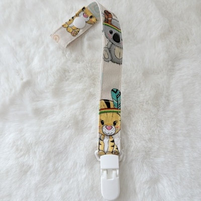 Correia de tecido com estampado de animais e presilha branca sobre fundo branco macio.