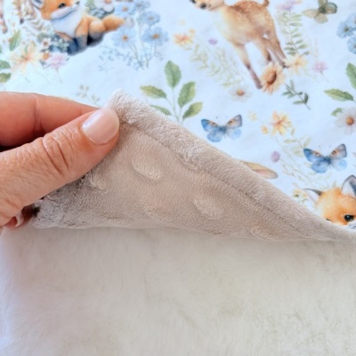 Tecido estampado com desenhos de animais como raposa, coelho e veado em tons pastel e tecido bege felpudo