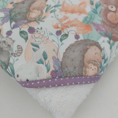 Detalhe de pano ou toalha com padrão colorido de animais e tecido felpudo branco