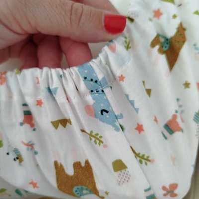 Tecido branco com estampado colorido de animais e elástico costurado