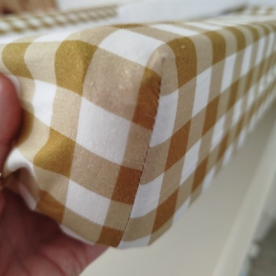 Canto de colchão com capa xadrez castanho claro, bege e branco