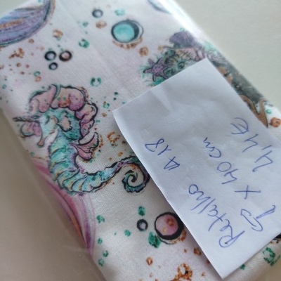 Pano branco com padrão de cavalinho-marinho colorido e papel manuscrito