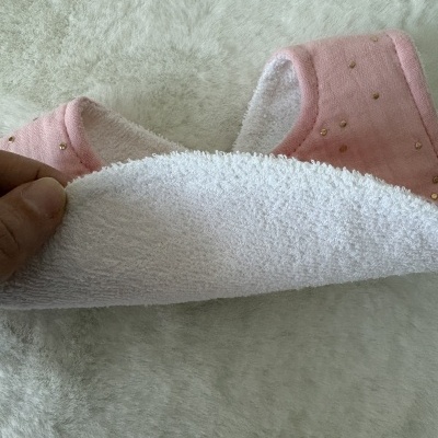 Babete rosa com pequenos brilhantes dourados e parte traseira branca de tecido esponjoso