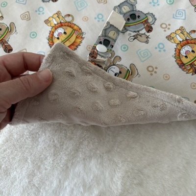 Cobertor para bebé com padrão de animais de peluche coloridos e tecido veludo cinza claro.
