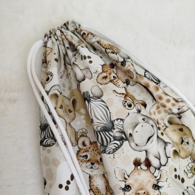 Mochila saco com padrão de animais da savana e cordões brancos