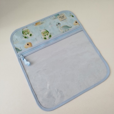 Capa ou bolsa azul com dinossauros e etiqueta Mamã pintinha