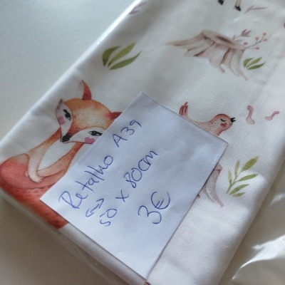 Tecido branco com estampado de animais e plantas e nota manuscrita