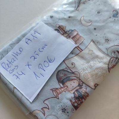 Peça de tecido infantil azul claro com desenho de menino e estrelas, embalagem com etiqueta manuscrita