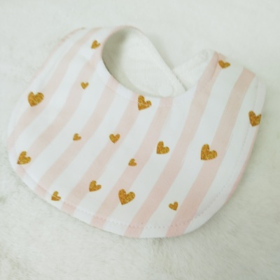 Babete de bebé com riscas cor-de-rosa e corações dourados.