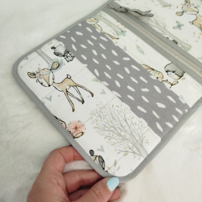 Estojo de tecido com padrão de animais da floresta e folhas em tons neutros