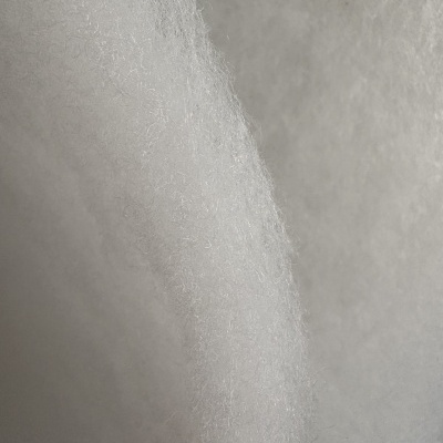 Espuma branca com textura fibrosa em fundo neutro