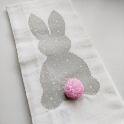 Toalha branca com aplicação de coelho cinzento às estrelas e pompom rosa