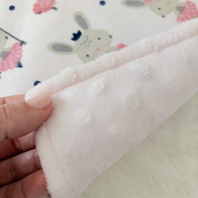 tecido com estampa de coelhinhos e flores e lado reverso rosa claro texturizado