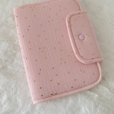 Capa rosa com bolinhas douradas e fecho de pressão