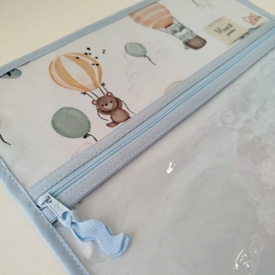 Estojo transparente com fecho azul claro e estampado de balões e urso