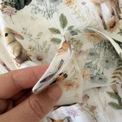 Tecido branco com padrão de animais silvestres e flores coloridas em relevo