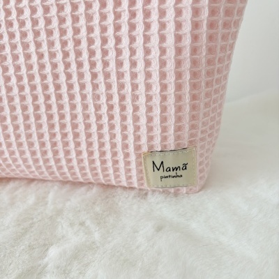 Tecido rosa com padrão tipo waffle e etiqueta Mamã pintinha em fundo branco macio