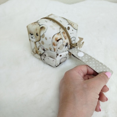 Estojo quadrado em tecido com estampado de animais e alça bege com pontos brancos