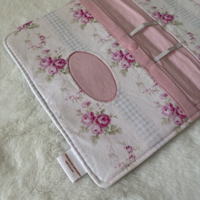 Estojo de tecido floral rosa e creme com botão de pressão e elásticos brancos